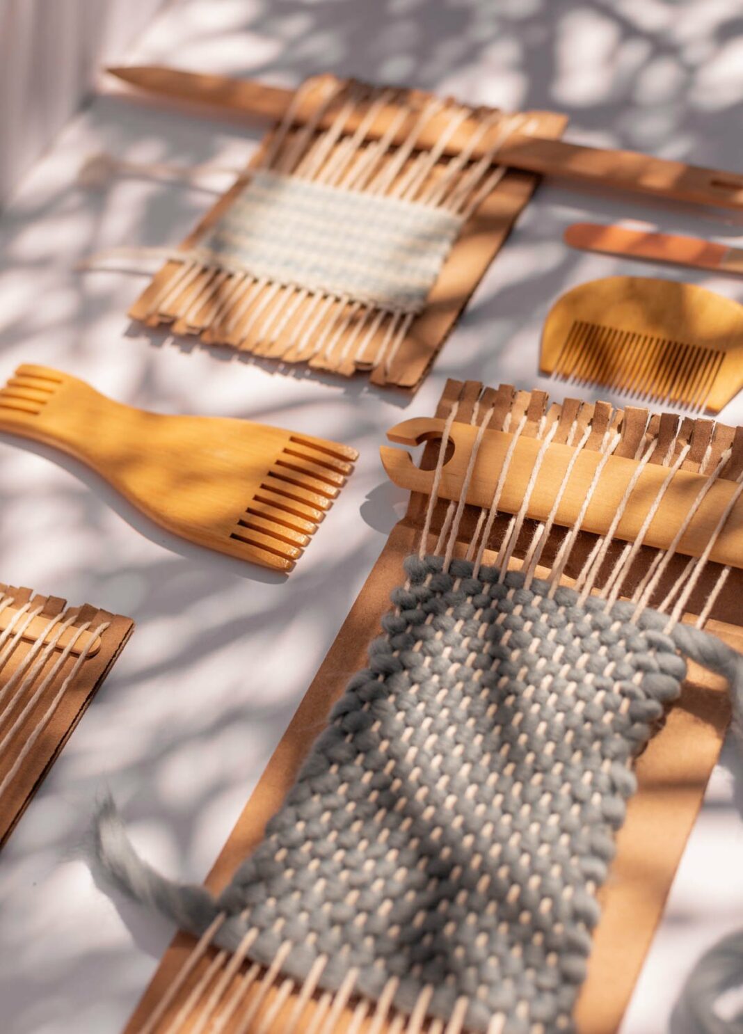 cardboard weaving looms laid out at various stages of the weaving process